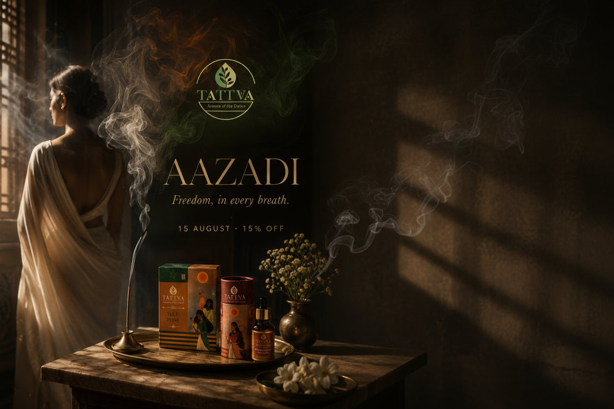 A promotional lifestyle scene for Tattva Aazadi incense products. A woman in a draped white garment stands in a dimly lit room with a incense burner smoking, while several Tattva incense boxes and bottles rest on a table in the foreground.